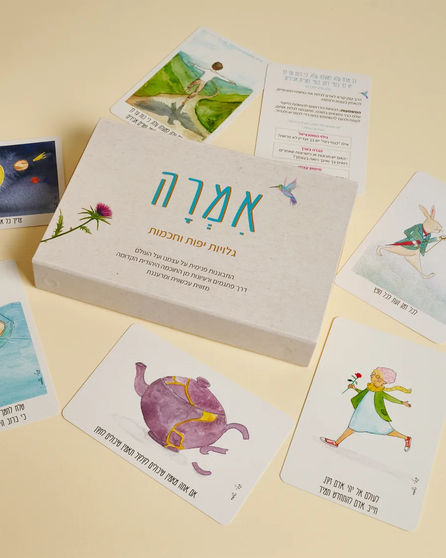 קופסת אִמְרָה פתוחה לצד גלויות פזורות על השולחן